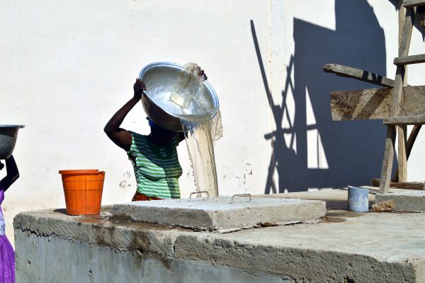 Das Wasser wird in einer langen Schlange in die Zisterne gekippt.